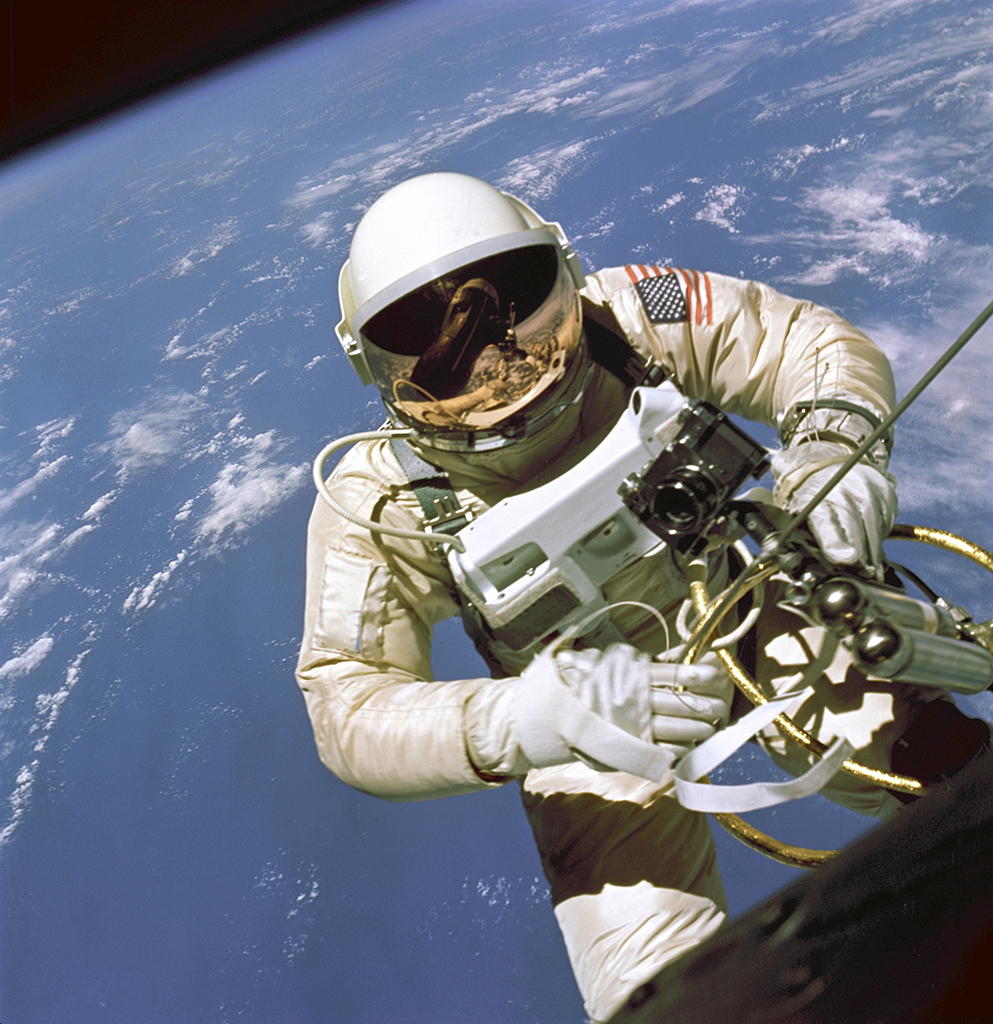 Ed White in astronaut suit floating above earth during a space walk