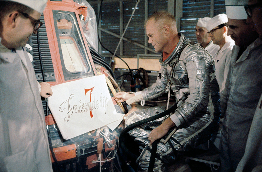 Astronaut and five other men look at Friendship 7 sign design for space capsule