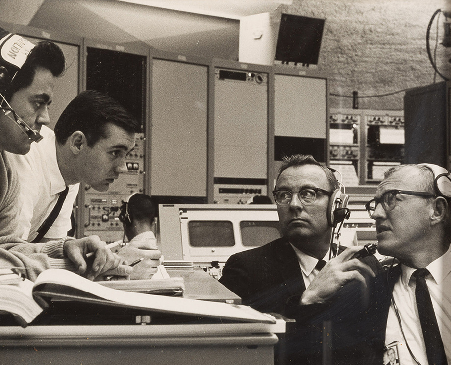 Four NASA scientists, including Arthur Case, work in a control room